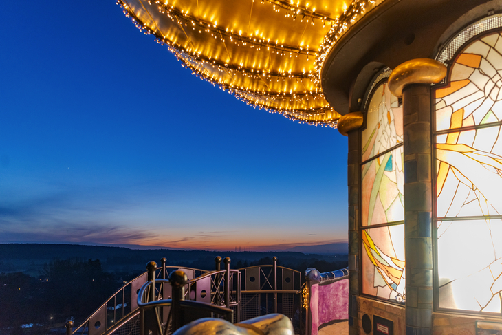 Abendstimmung am beleuchteten Kuchlbauer Turm mit Glasfenster und Aussicht auf Landschaft