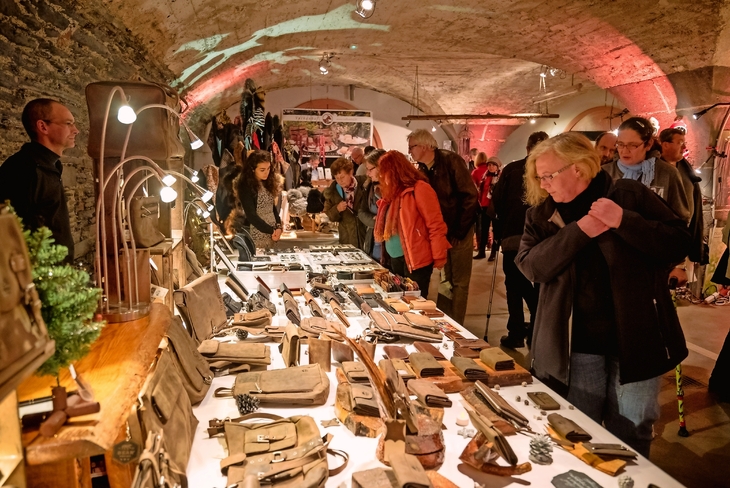 Besucher betrachten handgefertigtes Kunsthandwerk
